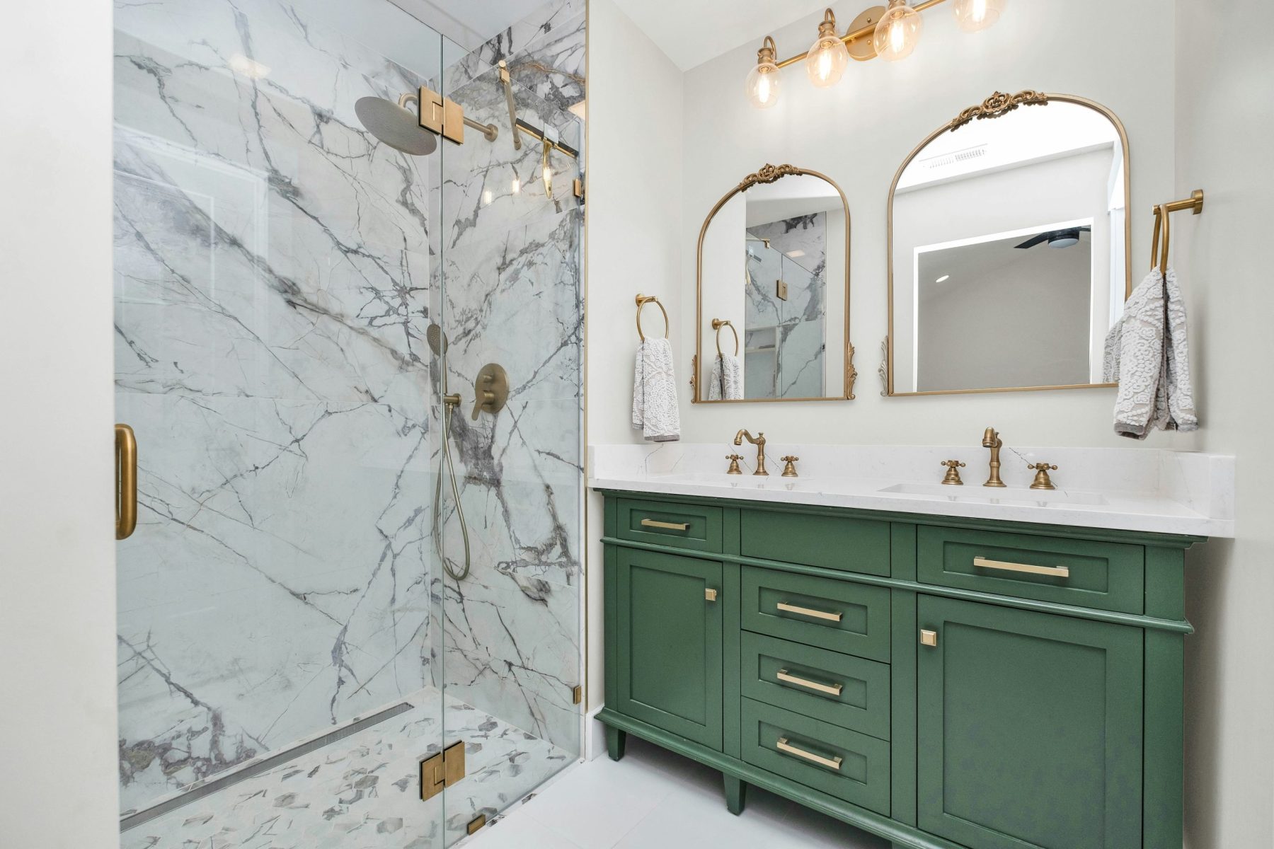 bathroom with green cabinets and marble shower