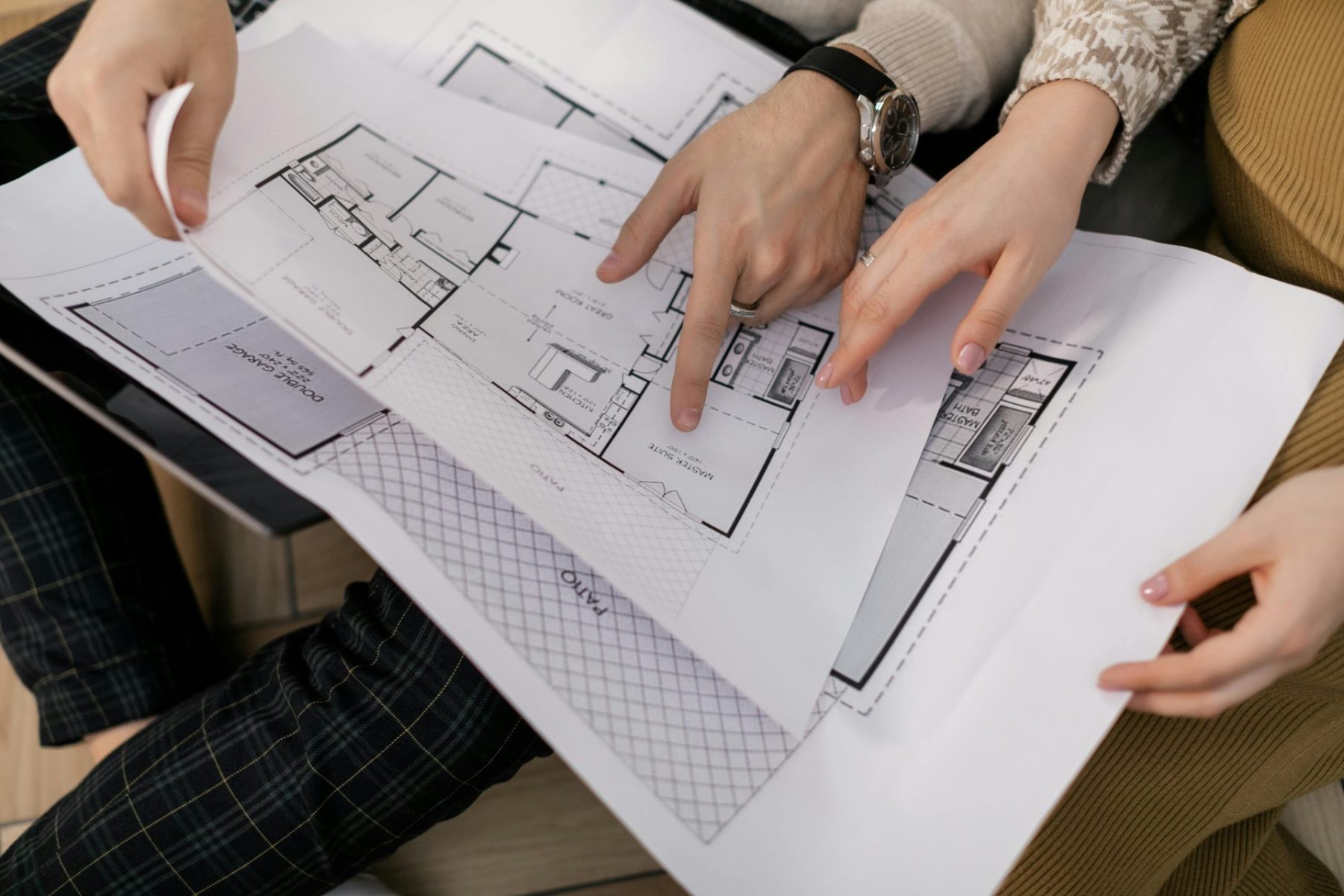 hands holding sketches of home project