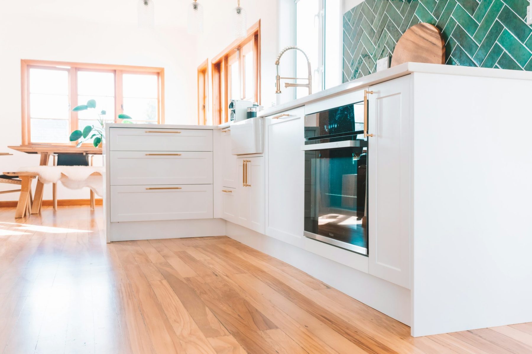 kitchen with green tile backsplash and white cabinets