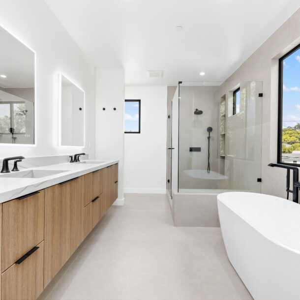 Primary bathroom with freestanding tub, quartzite vanity, and 48x48 ceramic tile walls for a spa-inspired design.