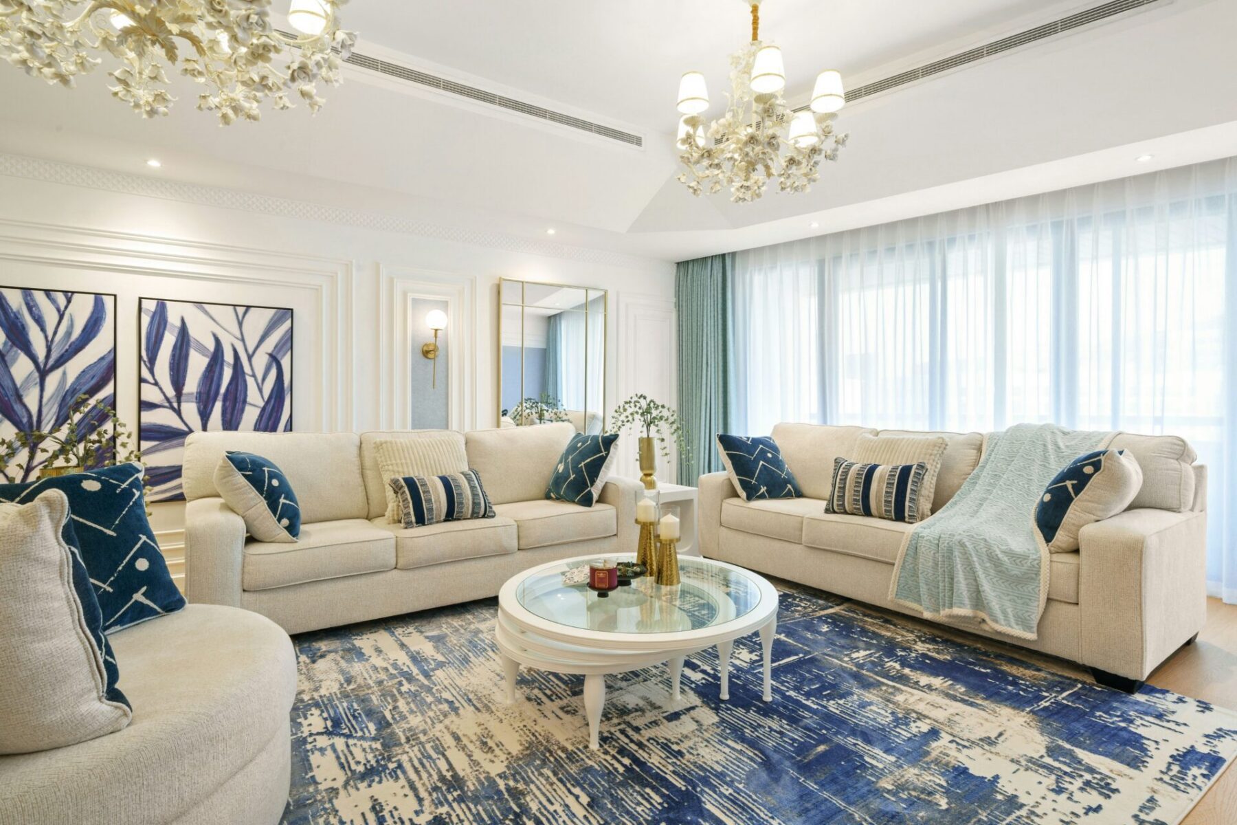 a living room with chandeliers and white sofas