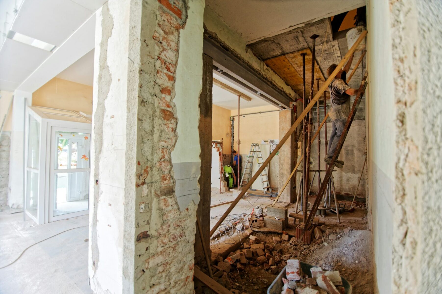 man climbing on ladder in a home under construction