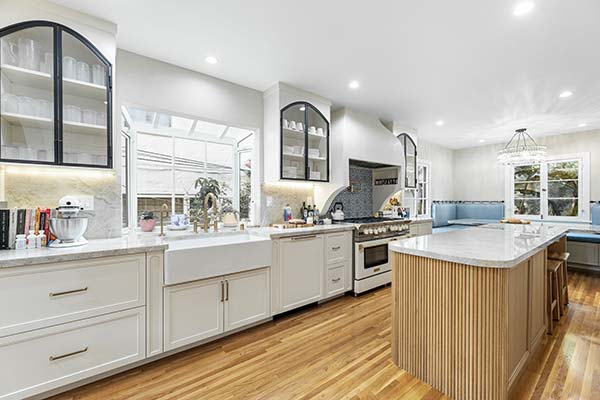 Custom kitchen remodeling project featuring a large island, custom cabinetry, marble countertops, and luxury finishes