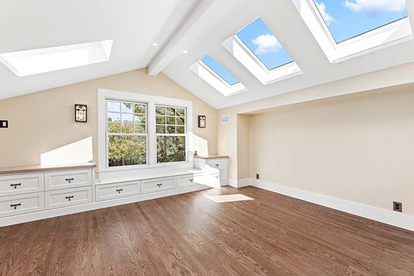 Second-floor home addition featuring multiple skylights, custom cabinetry, built-in bench seating, and abundant natural light