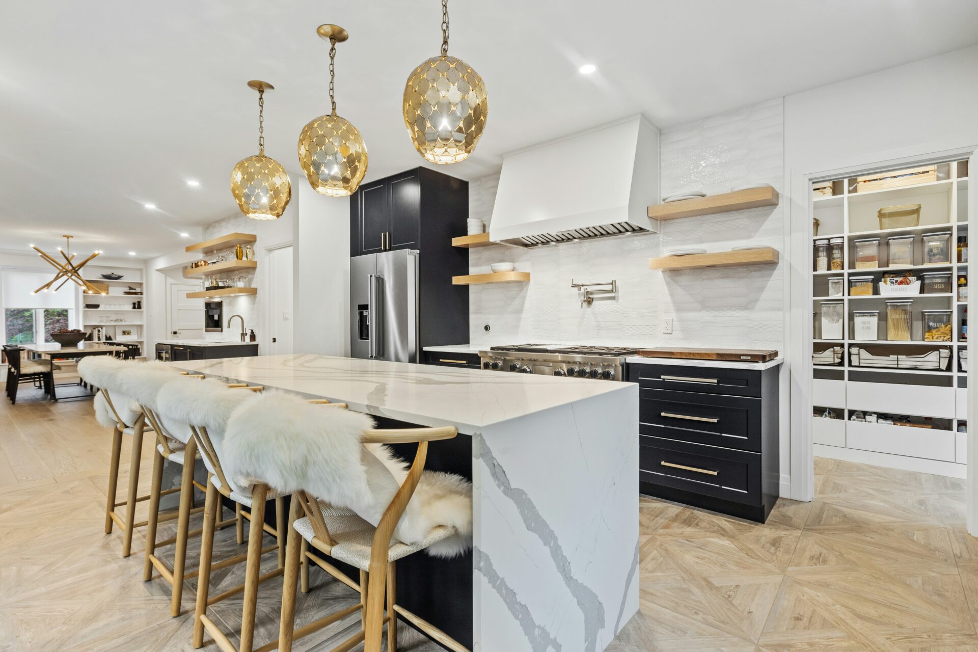A large kitchen island and gold light fixtures
