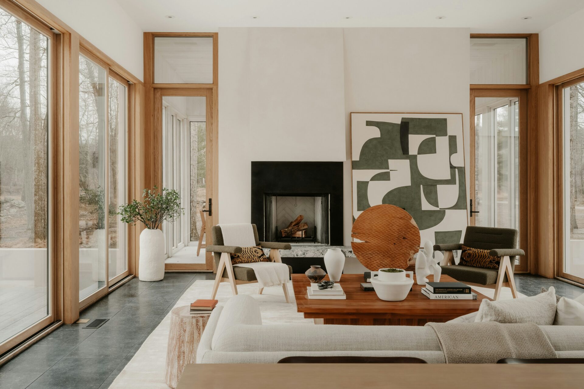 A living room with a fireplace and large windows